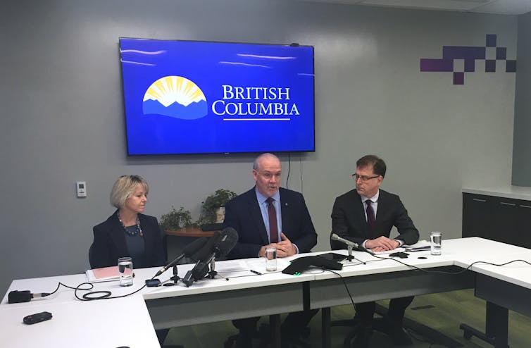 Premier John Horgan, centre, Provincial Health Officer Dr. Bonnie Henry, left, and Health Minister Adrian Dix
