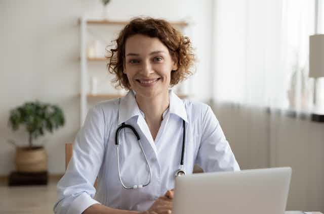 Female GP with stethoscope smiling