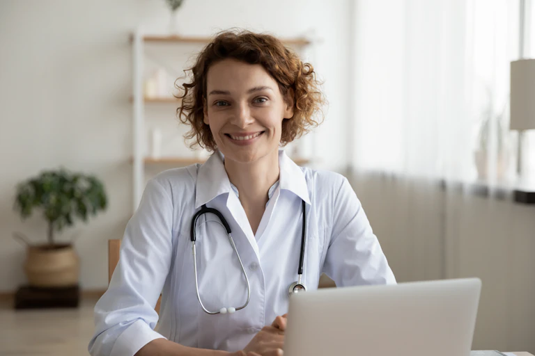 Female GP with stethoscope smiling