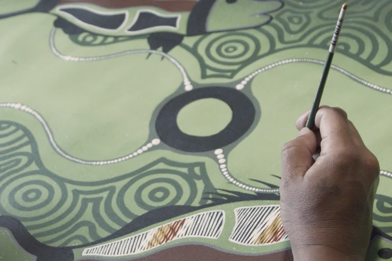 man's hand creating painting