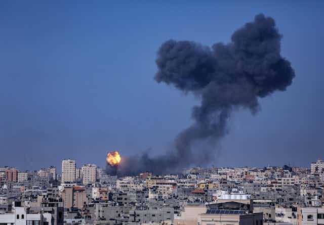 Skyline of Gaza City showing a tower block on fire.