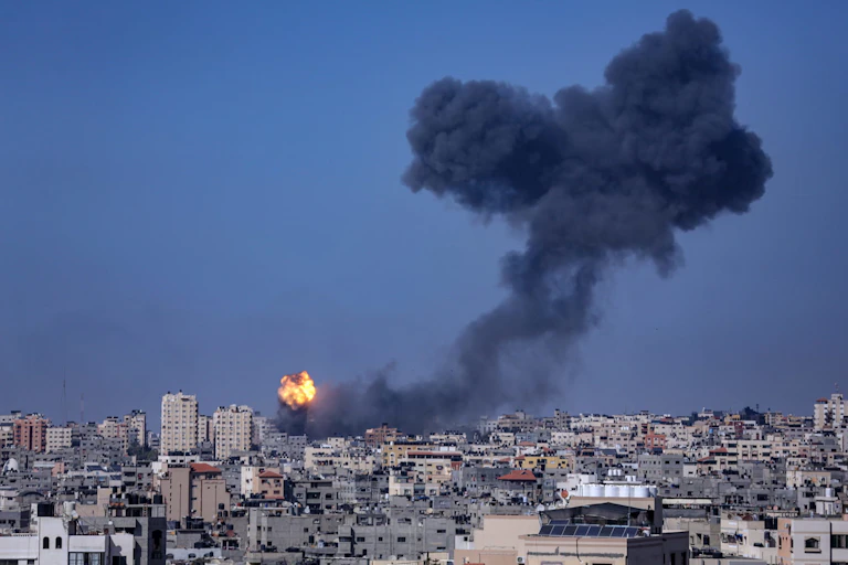 Skyline of Gaza City showing a tower block on fire.