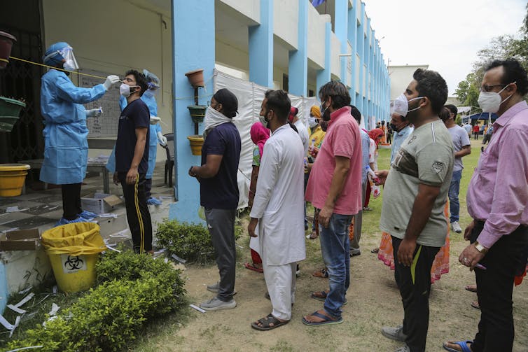 People lining up to receive a COVID test in India.