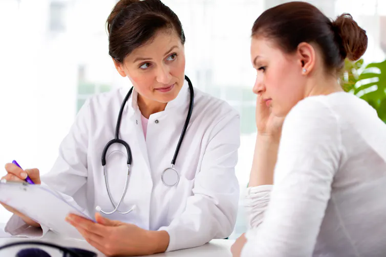 Female doctor discusses test results with female patient.