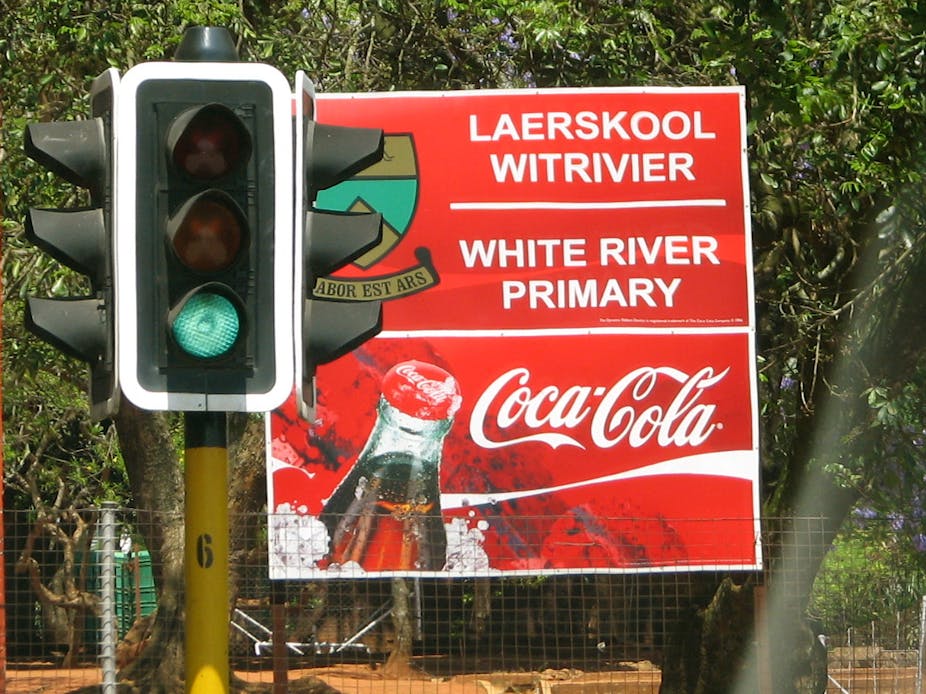 A sign at a school with sponsorship from Coca Cola.