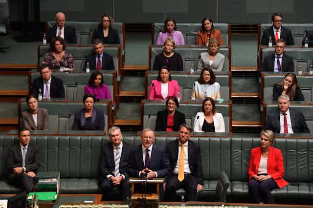 Anthony Albanese delivering his 2021 budget reply in the House of Representatives, with fellow MP's sitting behind him 