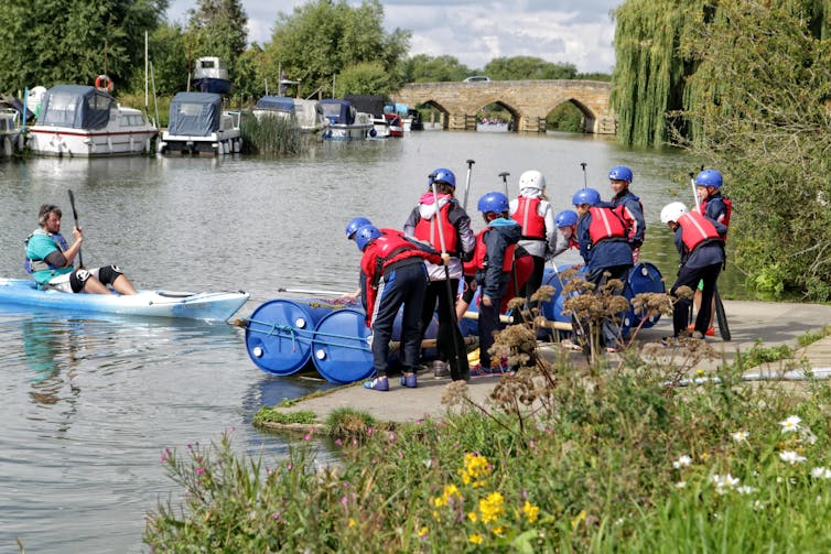 A group of school children learn about kayaking on the Thames in Oxfordshire