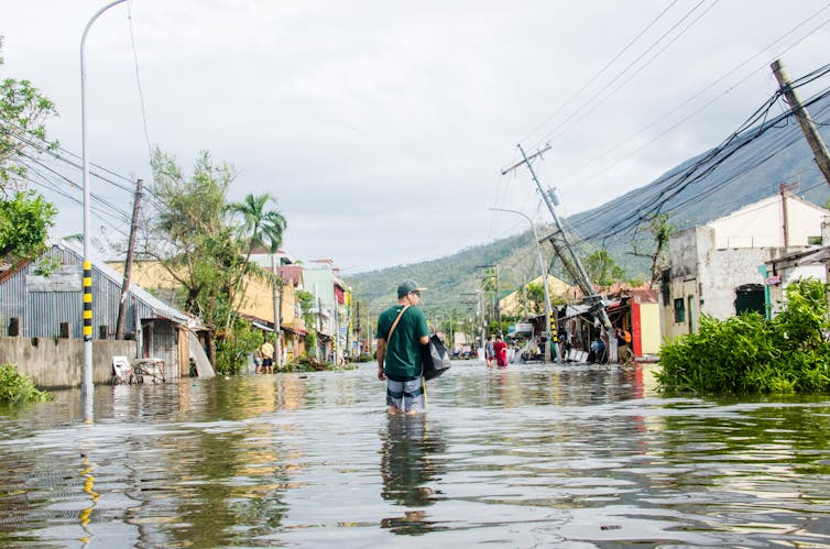 Man walks through flooded street