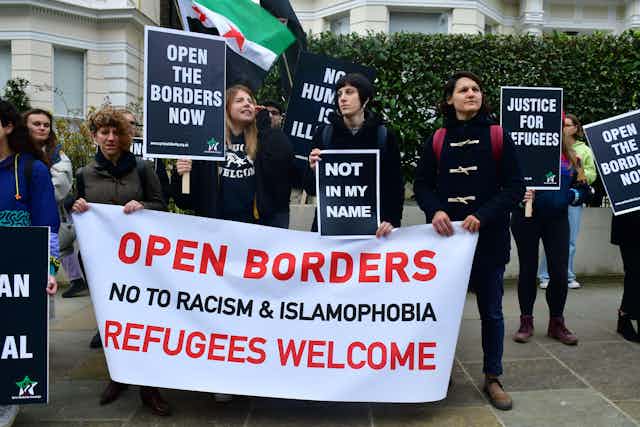 Protesters against Fortress Europe hold up banners demanding that borders be open and justice for refugees
