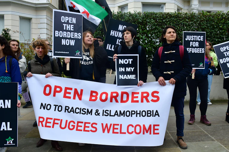 Protesters against Fortress Europe hold up banners demanding that borders be open and justice for refugees