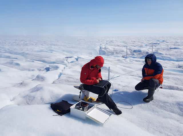 Scientists study equipment on an icy tundra