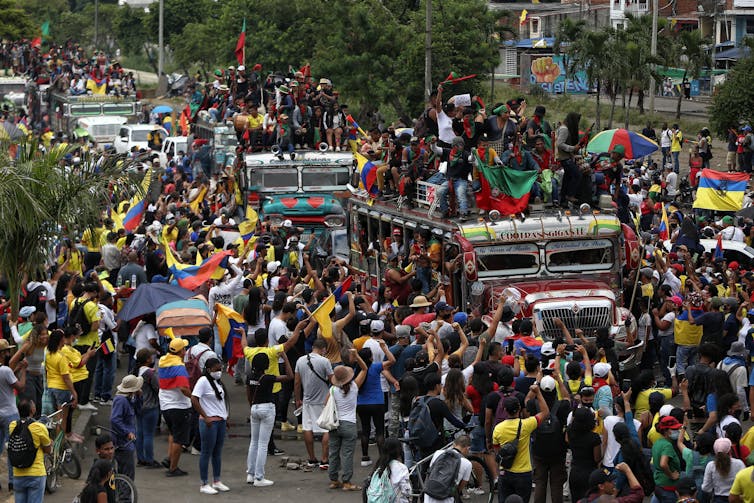 Des autobus remplis de manifestants circulent parmi la foule de marcheurs rassemblés dans les rue de Cali, en Colombie