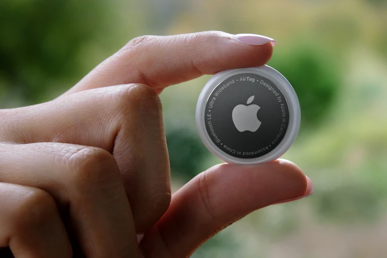 Hand holding Apple AirTag