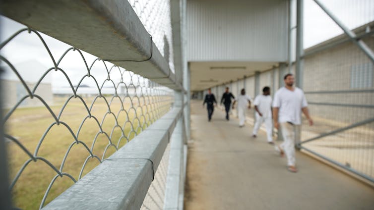 Staff escorting prisoners through a prison.