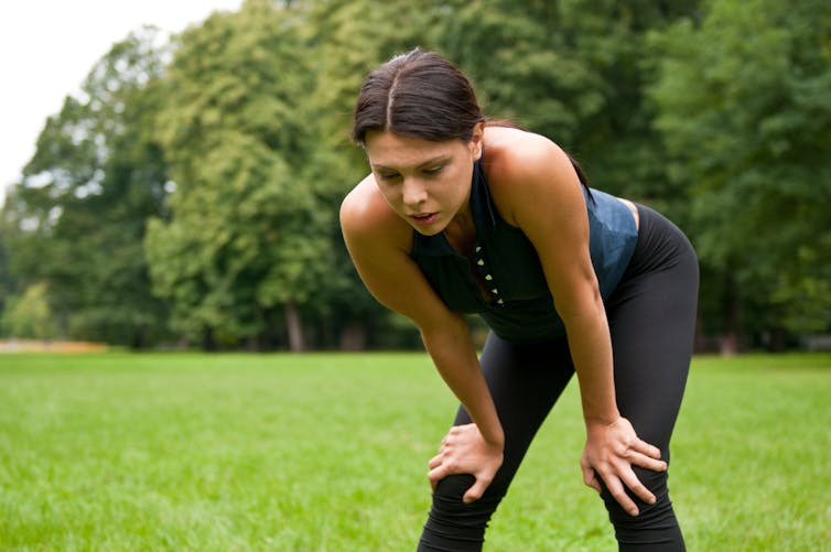 Tired woman catches her breath after a run in the park.