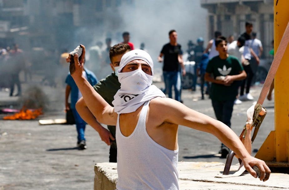 Un jeune Palestinien lance des pierres 