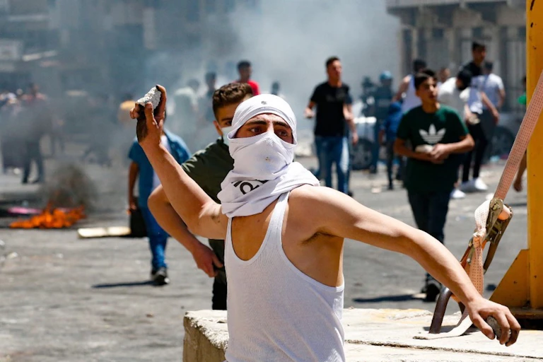 Un jeune Palestinien lance des pierres