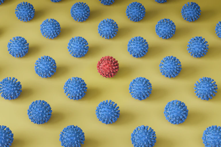 One red 3D-printed virus particle among many blue particles.