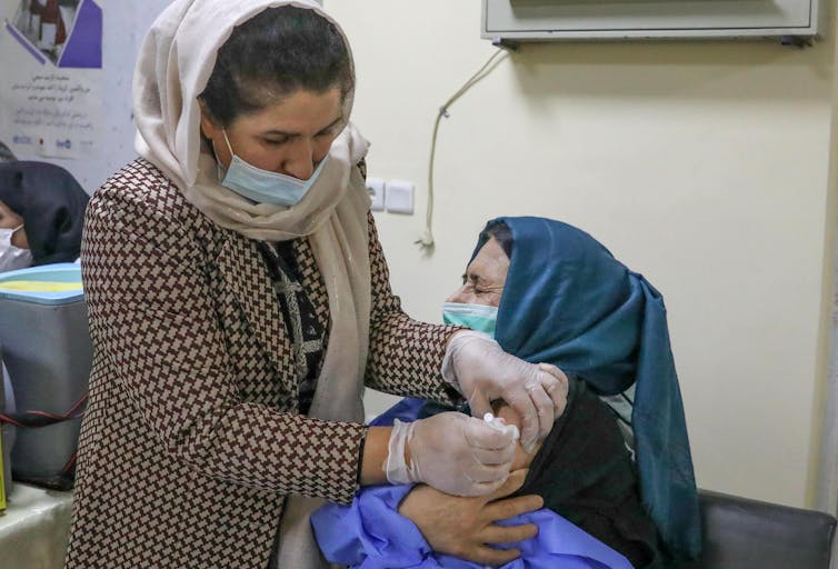 A health worker being vaccinated from COVID in Kabul, Afghanistan.