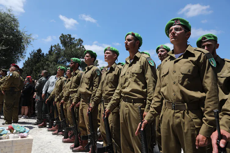 Israeli soldiers standing at attention over a coffin