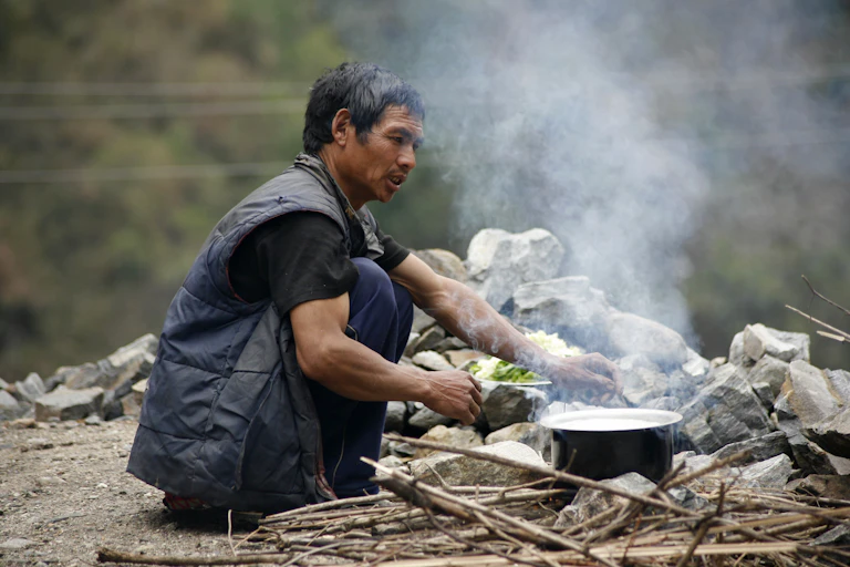 Man cooks over wood fire