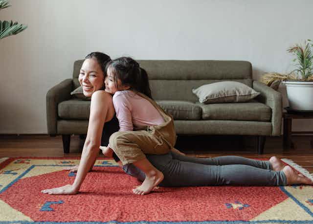 A woman doing yoga with a child