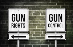 Sign that says 'gun rights' with an arrow pointing one way and sign that says 'gun control' with the arrow pointing in the opposite direction.