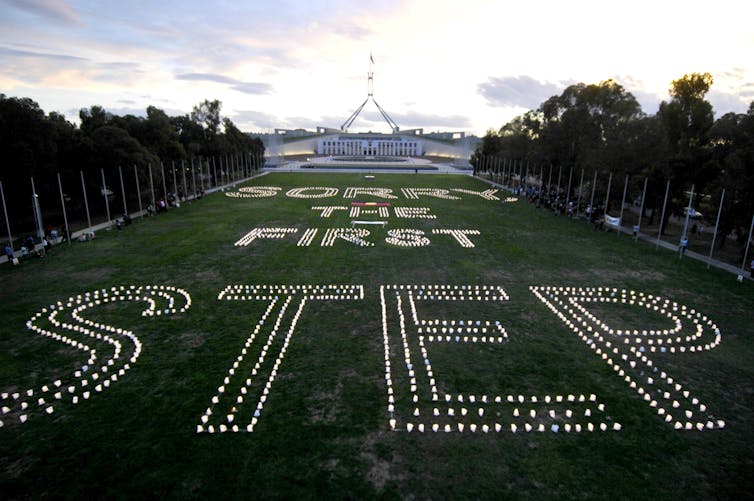 Candles outside parliament house spell 'Sorry is the first step'