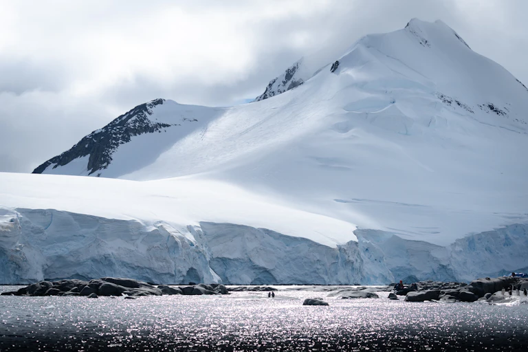 Penguins near an icy cliff in Antarctica