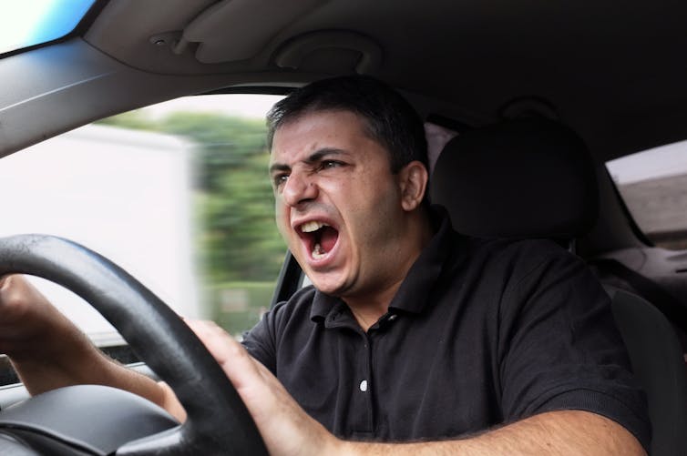 Angry man yells while driving