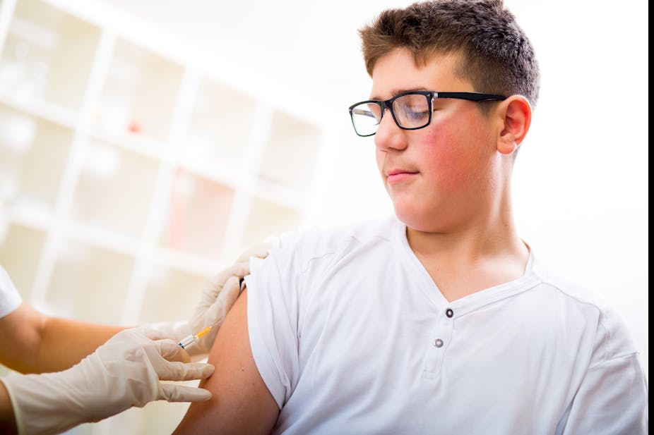 A teenage boy receives a vaccination.