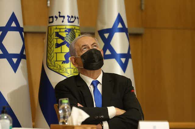 Israeli prime minister Benjamin Netanyahu, wearing a COVID mask, folds his arms and looks to the sky on Jerusalem Day, May 9 2021.