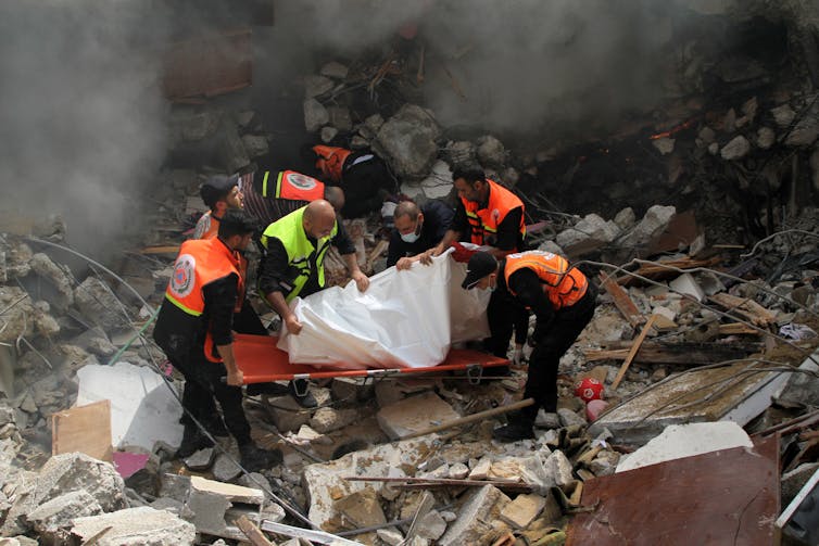 Palestinian civil defense members rescue a man.