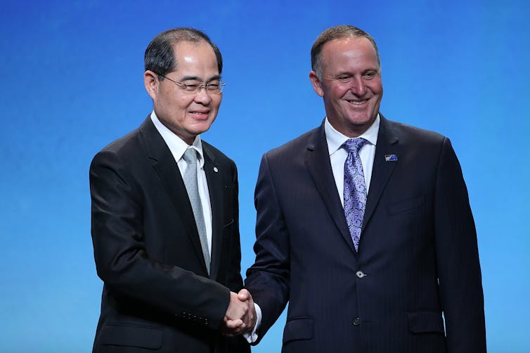 Singapore's Minister for Trade and Industry Lim Hng
Kiang shaking hands with New Zealand Prime Minister John
Key