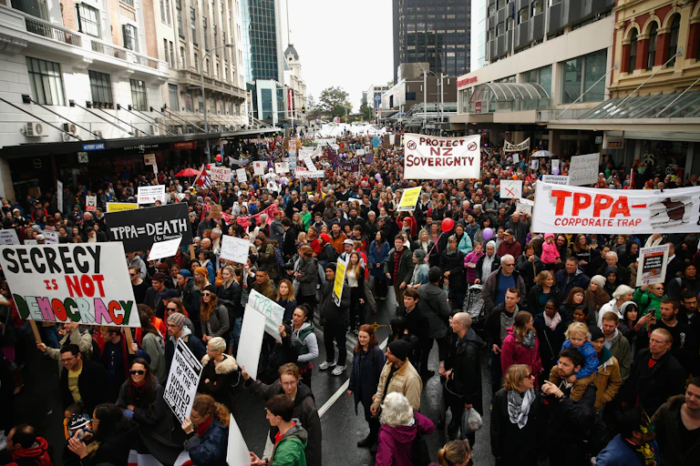 Protesters at a rally with anti TPPA signs