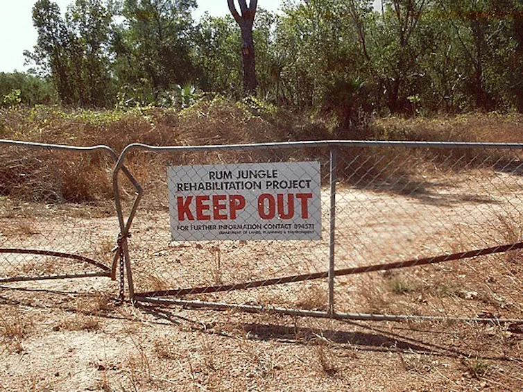 A sign for Rum Jungle rehabilitation on a fence