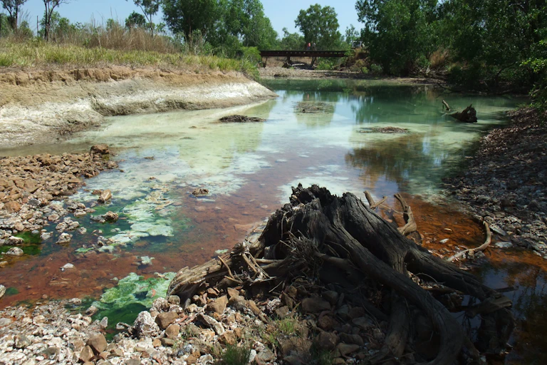 Red and green contaminated water in a river