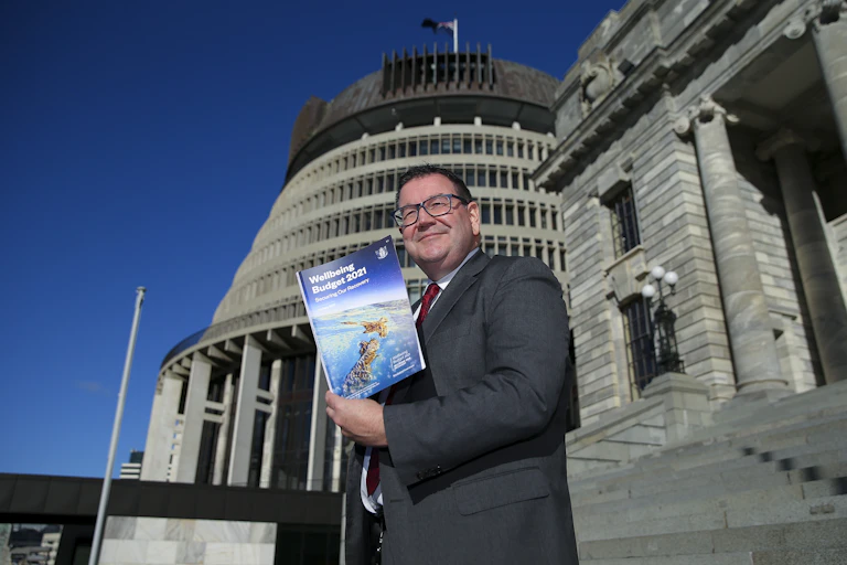 Finance Minister Grant Robertson holding a copy of Budget 2021 in front of parliament