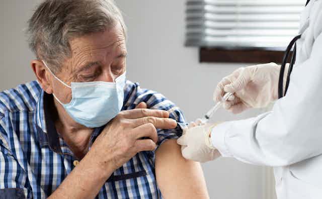 An elderly man being vaccinated