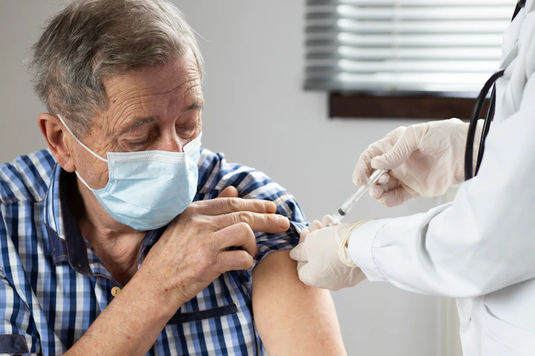 An elderly man being vaccinated