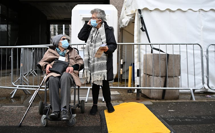Two elderly women leaving a COVID-19 vaccination centre