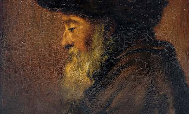The painted face of an elder man in profile, cracked canvas displaying his grey beard and hatted head, his eyelids drooping downwards.