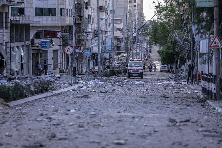 An ambulance driving through the streets of Gaza City that are littered with rubble after Israeli airstrikes, May 17 20201.