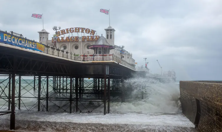 Waves crash against the UK's Brighton Pier in a storm.