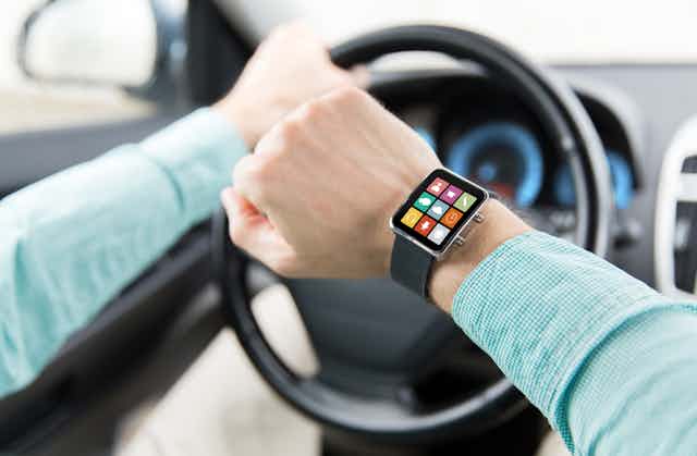 Close up of a person checking their smartwatch while driving