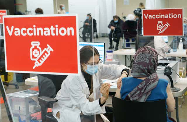 Une femme reçoit son vaccin lors d'une clinique de vaccination au Stade olympique.