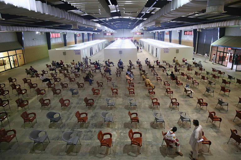 Pakistani citizens wait to receive a dose of the AstraZeneca's (AZD1222) vaccine against Covid-19, during the second phase of Pakistan's coronavirus vaccination drive in Karachi, Pakistan