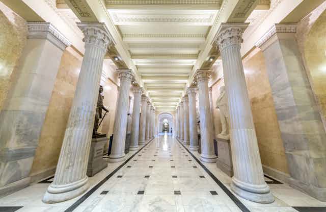 A long, marble-lined corridor with columns and statuary in the U.S. Senate.