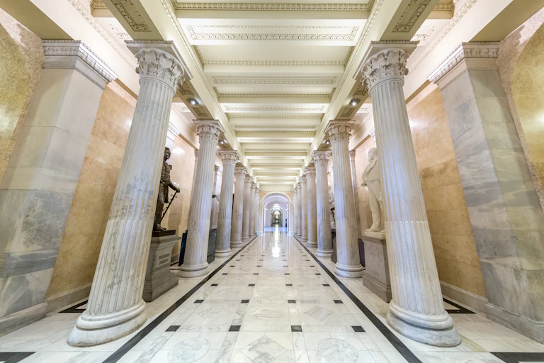 A long, marble-lined corridor with columns and statuary in the U.S. Senate.