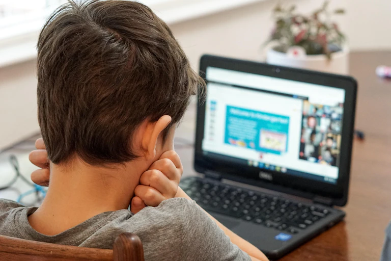 A boy works on a laptop